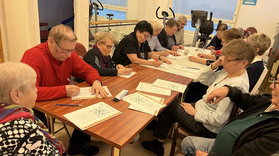 Kuvassa senioritalon asukkaat tekevät aivotreenejä.